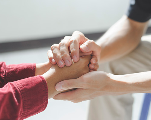 Hände halten sich während der Psychotherapie in der Diabetes Reha Klinik.